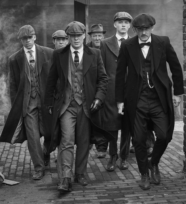 a group of men walking down a street next to each other in suits and ties