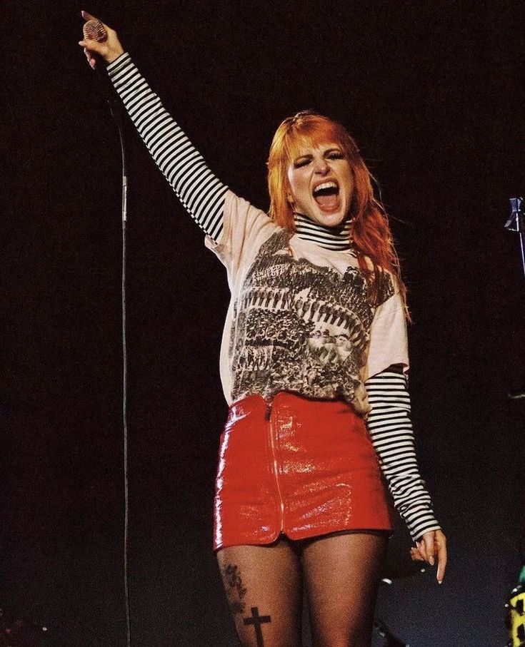 a woman with red hair is singing on stage