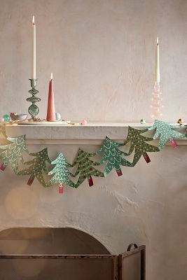 a mantle with candles and christmas decorations on it