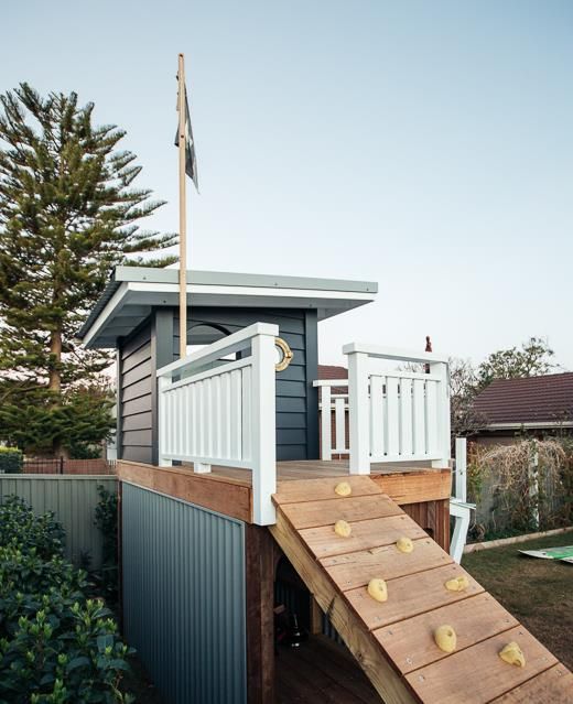 a small house with a deck and stairs leading up to it