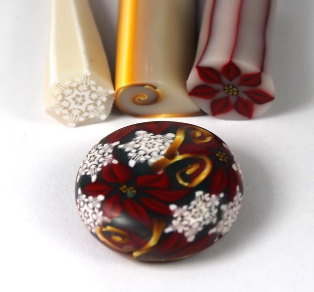 four different colored candles sitting next to each other on a white surface with snowflakes