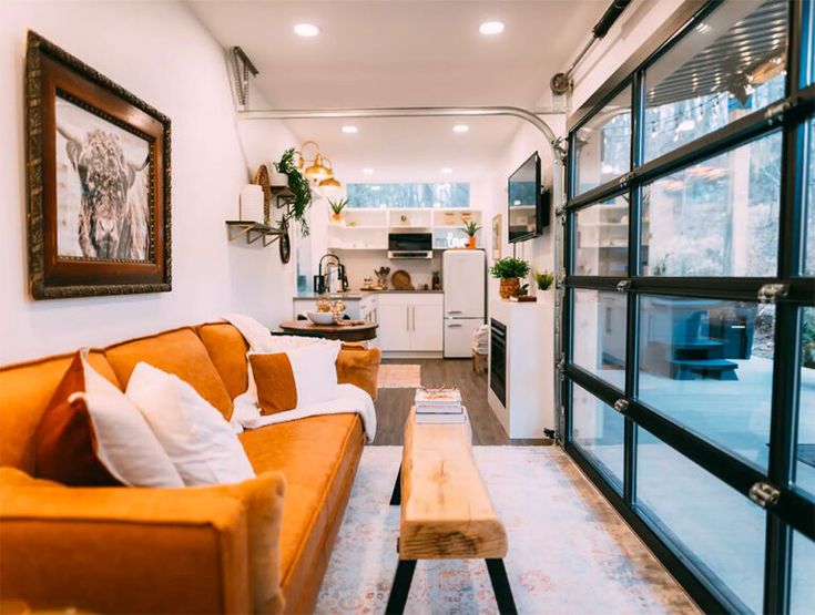 a living room filled with furniture next to a window covered in lots of glass doors