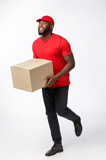 a man in a red shirt is carrying a box