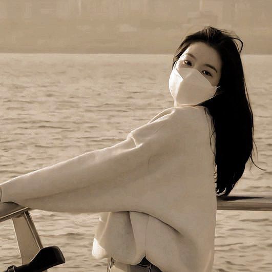 a woman wearing a face mask while standing on a boat