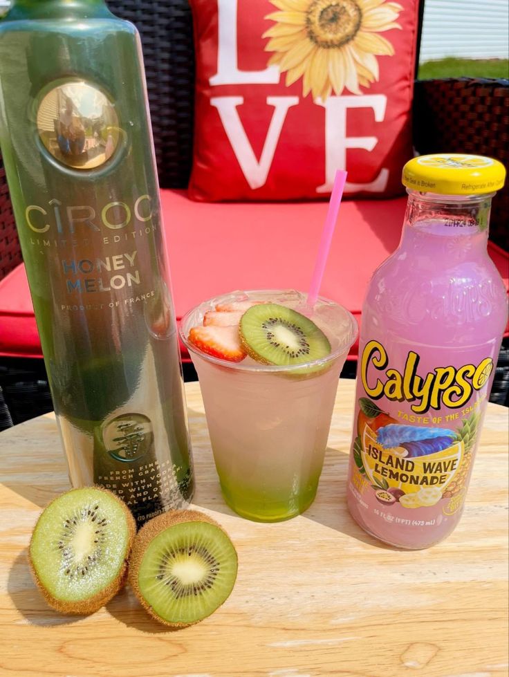 a bottle of calories and some kiwi slices on a table with a drink