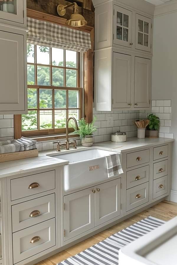 a kitchen with white cabinets and an open window above the sink is seen in this image