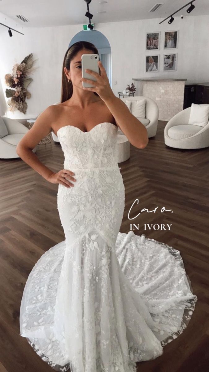 a woman is taking a selfie in her wedding dress while standing on the floor