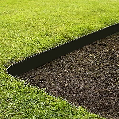 a garden bed in the middle of some grass with dirt on it and a shovel laying next to it