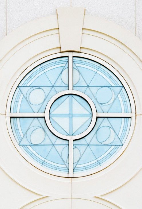 a circular window with an abstract design in the center and blue glass on the outside