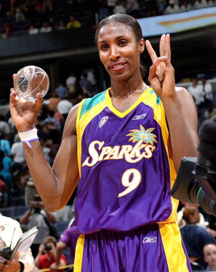 a female basketball player is holding up the peace sign with one hand and two fingers