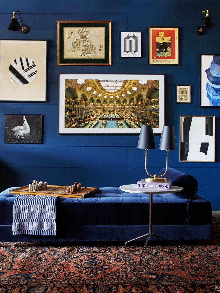 a living room with blue walls and pictures on the wall