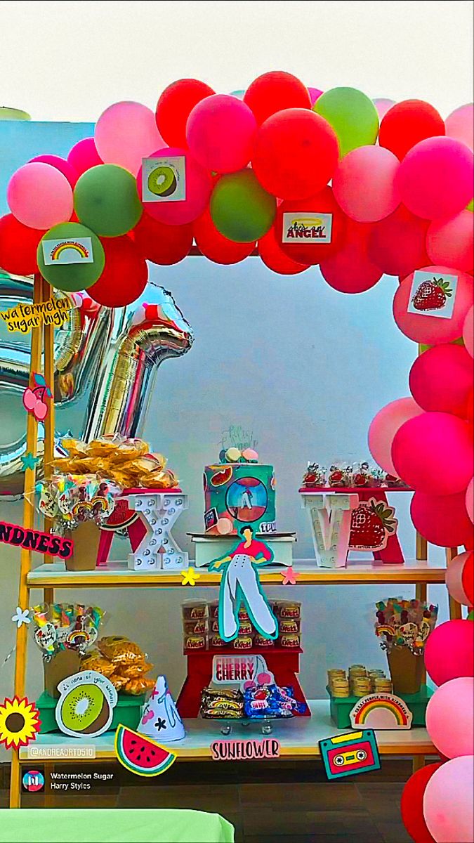 a table topped with lots of balloons and cake