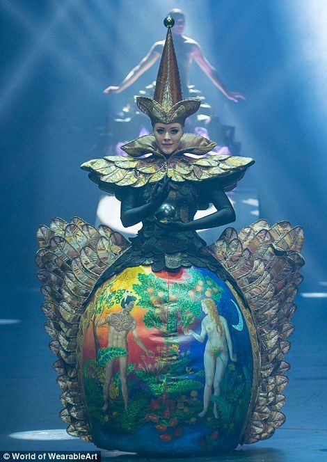 a woman standing on top of a colorful ball in the middle of a stage setting