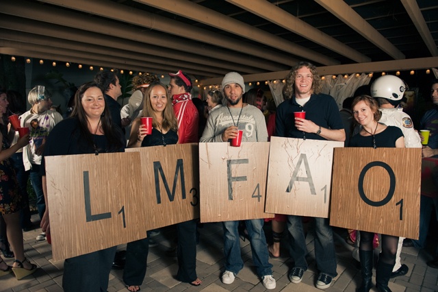 a group of people holding wooden signs that say lmfao and one person is holding a cup