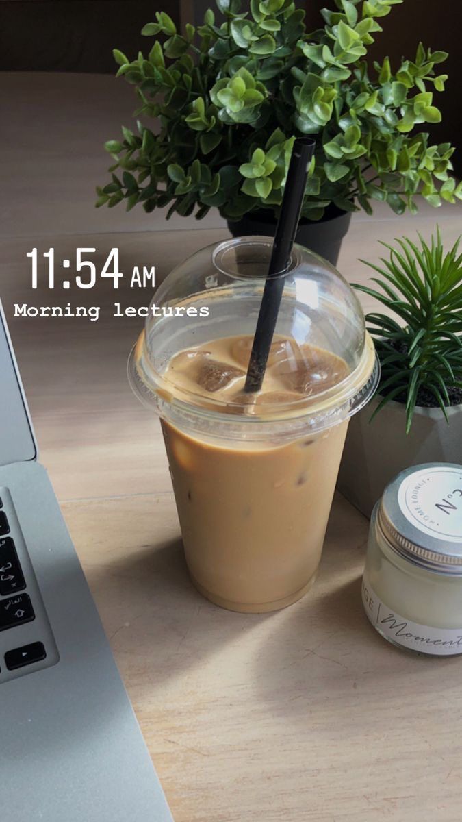 a laptop computer sitting on top of a wooden table next to a cup of coffee