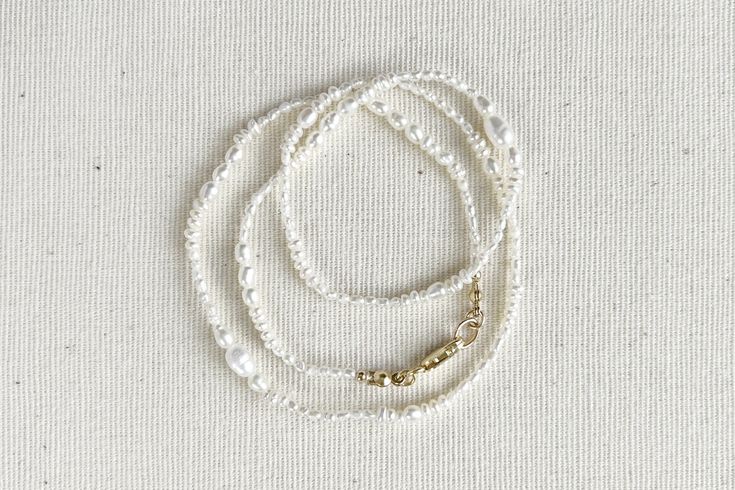 It isn't perfection, but our unique individualism, that gives us all beauty. Meet Esme, a delicate strand of multi-shapes and varying sizes of pearls strung together with artful beauty in mind. Dainty and sweet, perfect for any occasion. DETAILS Pearl diameter 1.5mm-5.5mm * Genuine freshwater pearls * 14k gold-filled | Sterling silver * Silk string * Handcrafted with love & care * Special order item * Complimentary gift wrapping service (See FAQ for details) SPECIAL ORDER ITEM Please note that e Elegant Everyday Beaded Pearl Necklace, Minimalist Single Strand Pearl Beaded Necklace, Elegant Hand-strung Multi-strand Jewelry, Hand-strung White Pearl Necklace For Wedding, White Hand-strung Necklaces For Wedding, White Hand-strung Wedding Necklaces, Everyday Beaded Pearl White Pearl Necklace, Dainty Single Strand Beaded Necklaces For Wedding, Delicate Pearl White Beaded Necklace With Round Beads