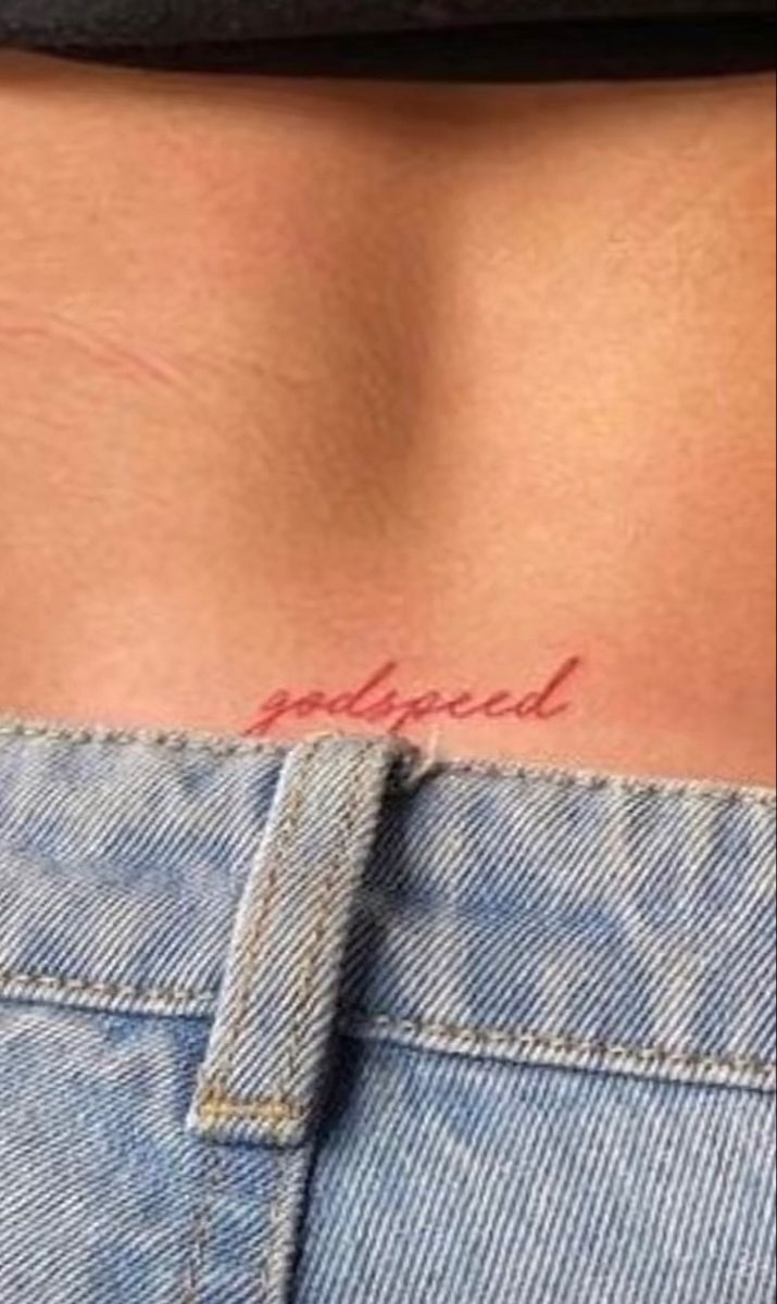 the back of a woman's stomach with an inscription tattooed on her left side