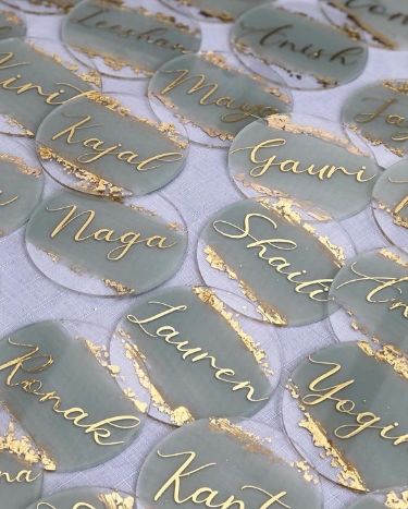 some silver and gold confetti stickers on a white table cloth with writing