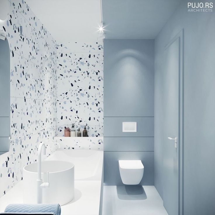 a modern bathroom with blue walls and white fixtures, including the toilet and bidet