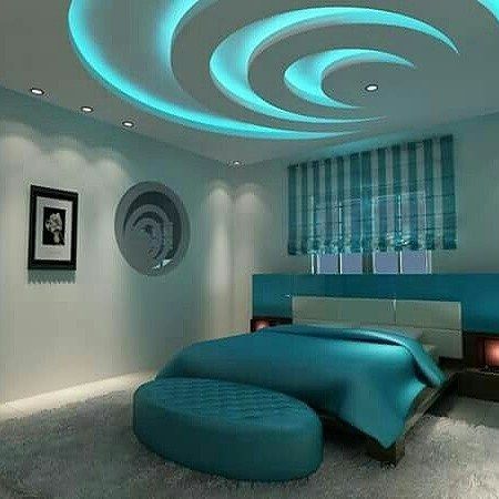 a modern bedroom with blue and white decor on the ceiling, round lights above the bed