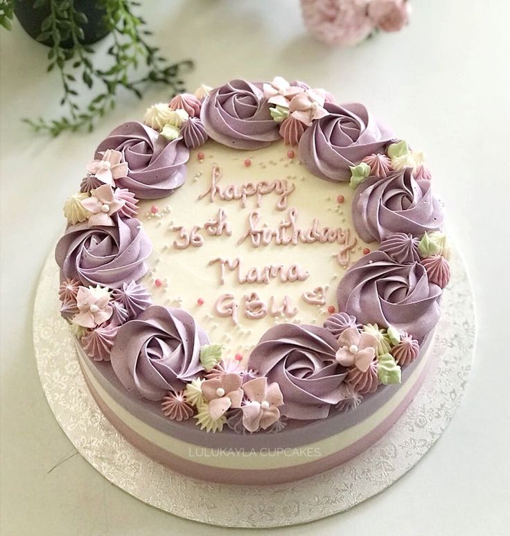 a birthday cake with purple frosting and flowers