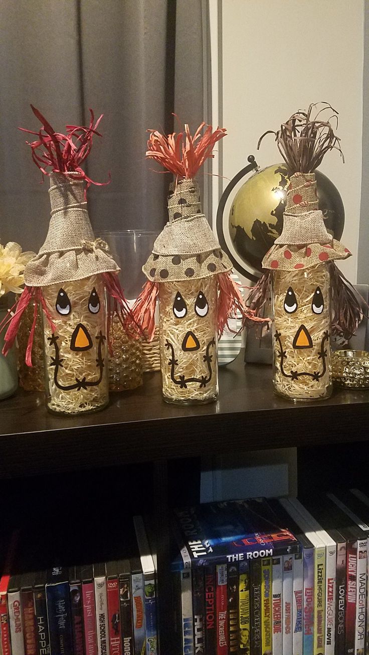 three vases with faces are on a shelf in front of a bookshelf