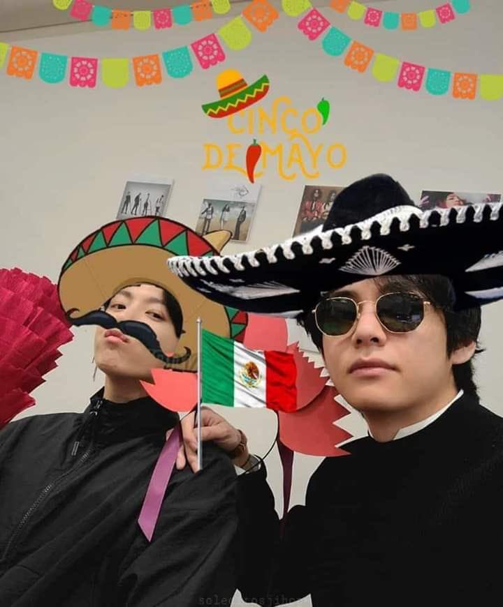 two people wearing sombreros and hats with flags