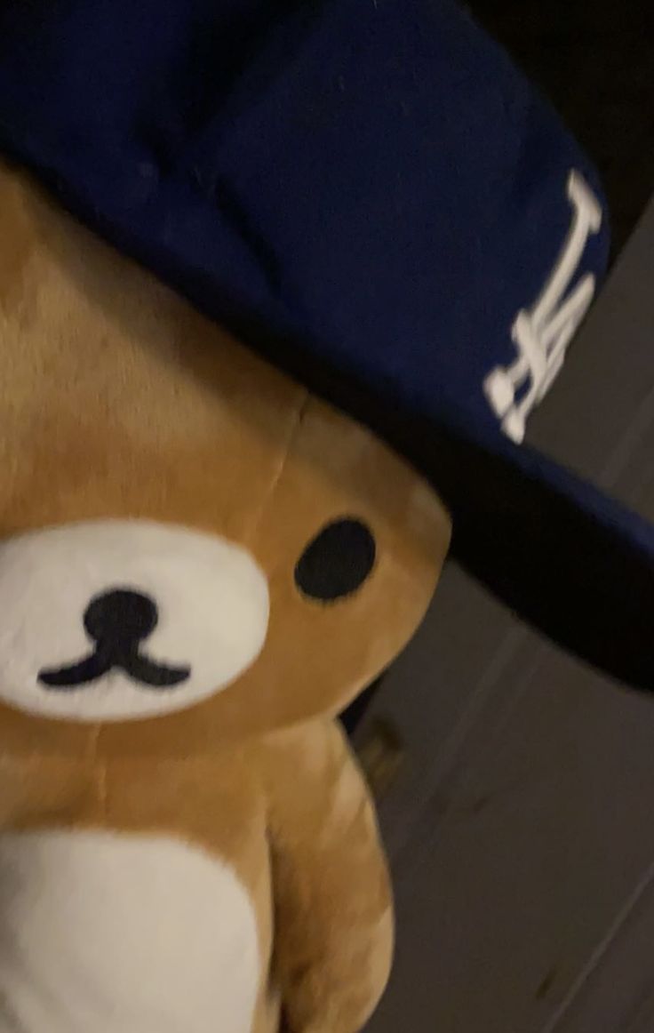 a brown teddy bear wearing a blue hat