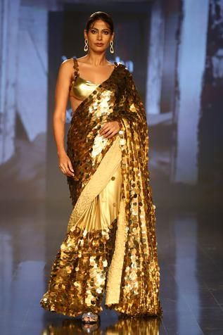 Gold saree with all-over sequin embroidery. Comes with sleeveless blouse and petticoat.
Component: 3
Pattern: Embroidery
Type Of Work: Sequin
Neckline: Sweetheart
Sleeve Type: Sleeveless
Fabric: Foil Georgette
Color: Gold
Other Details: 
Shoulder straps with sequin embroidery
Occasion: Wedding - Aza Fashions Glamorous Sleeveless Sequined Pre-draped Saree, Glamorous Sequined Pre-draped Saree For Festivals, Party Wear Pre-draped Sequined Saree For Festivals, Festive Blouse Piece With Sequins And Traditional Drape, Festive Sequined Blouse Piece With Traditional Drape, Diwali Sequined Traditional Drape Blouse Piece, Bollywood Style Sequin Fabric For Navratri, Traditional Drape Sequin Blouse Piece For Diwali, Navratri Festive Sequin Fabric