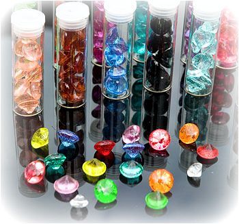 many different colored glass beads are lined up together