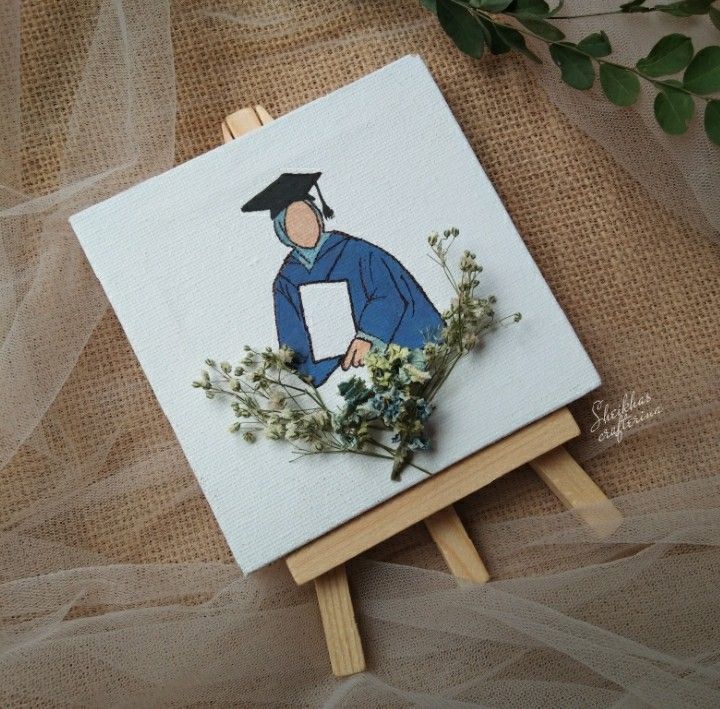 an easel with a drawing of a man in a graduation cap on it