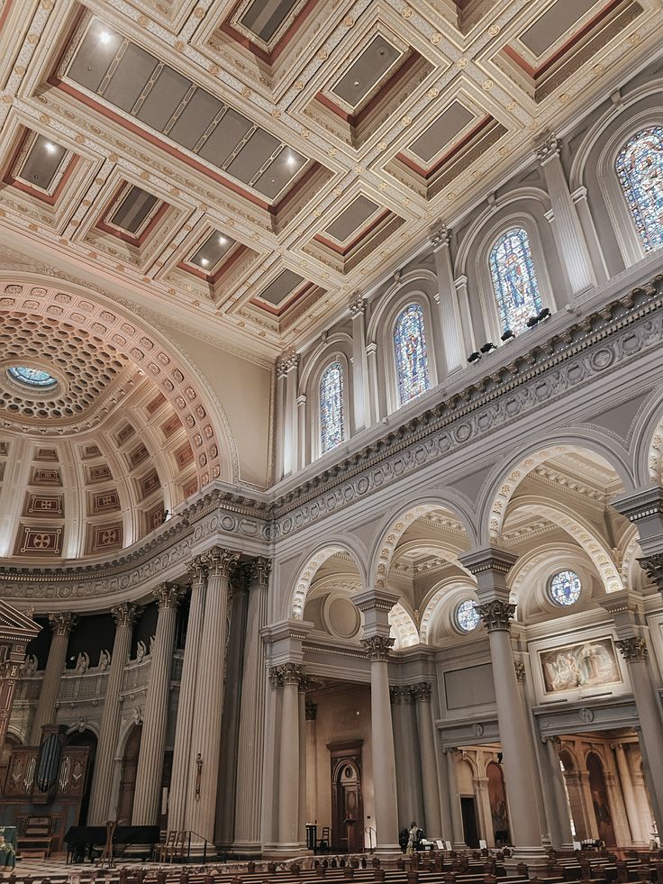 the inside of a church with pews and stained glass windows on the ceiling,