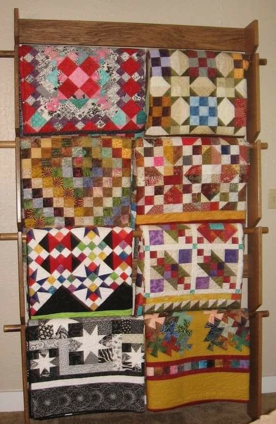 a wall hanging with several different quilts on it's sides and one is made out of wood