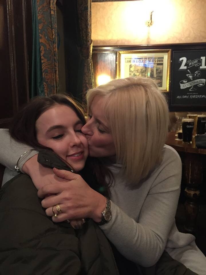 two women hugging each other in a room