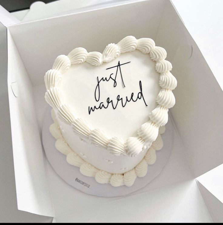 a heart - shaped cake with the words just married written on it in a box