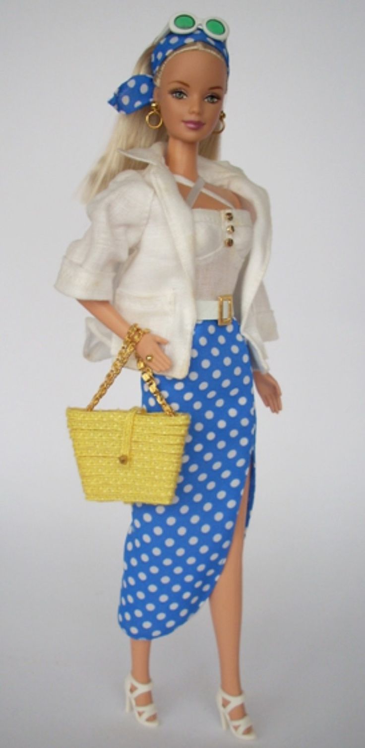 a barbie doll holding a yellow purse and wearing a blue polka dot skirt with white shoes