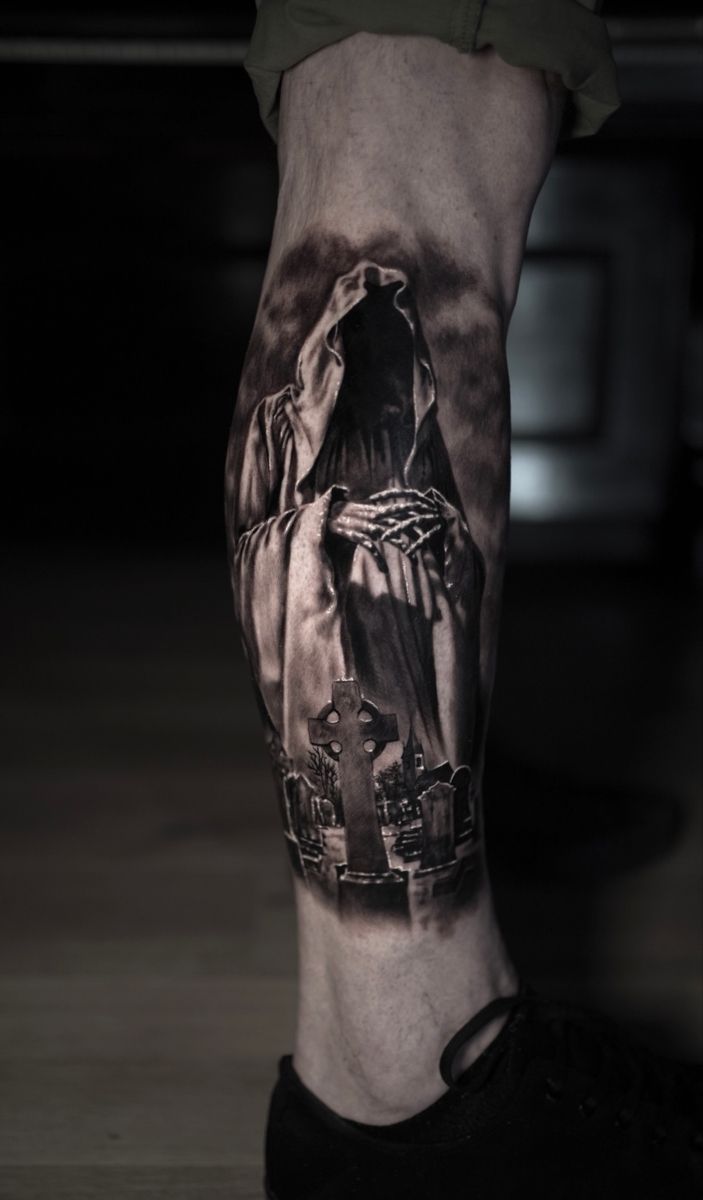 a man's leg with a black and white tattoo on it, depicting the statue of liberty