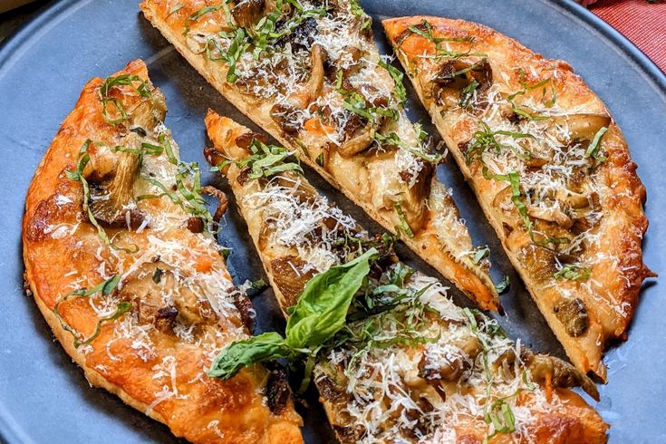 a blue plate topped with sliced pizza on top of a table