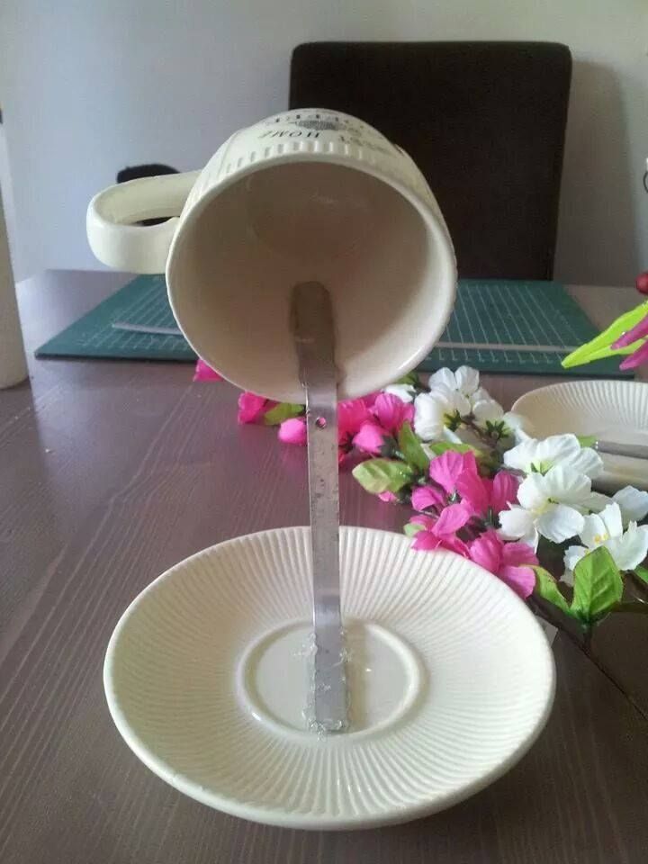 a table with plates and flowers on it, one is pouring water into the other