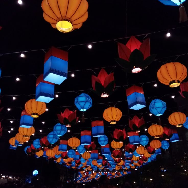 many colorful lanterns are hanging from the ceiling