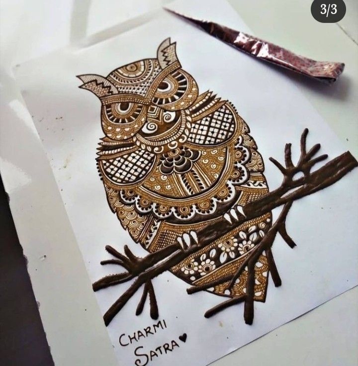 an owl is sitting on top of a piece of paper with some scissors next to it