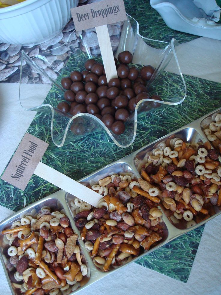 several trays filled with nuts sitting on top of a table next to other food items