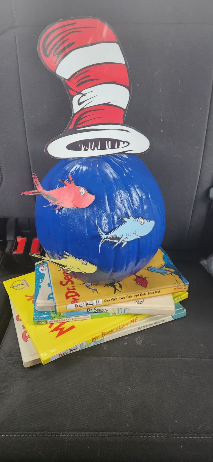 the cat in the hat pumpkin is sitting on top of some books and other children's books