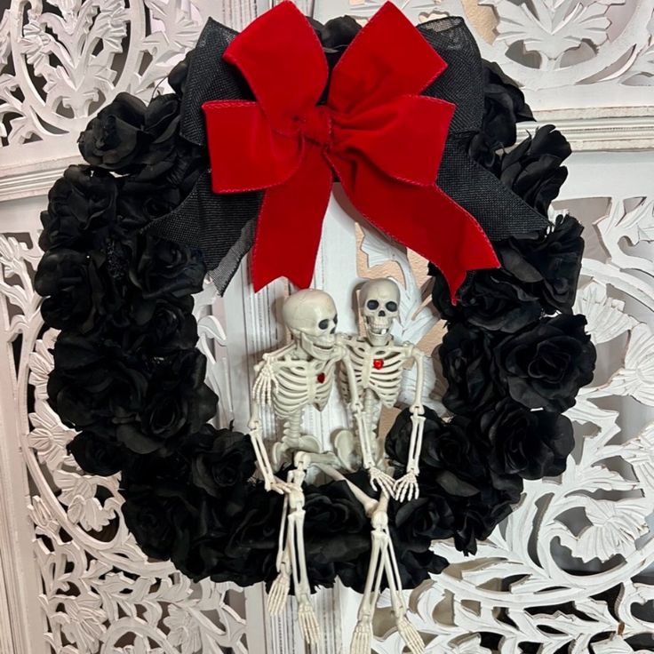 a wreath with two skeletons and a red bow