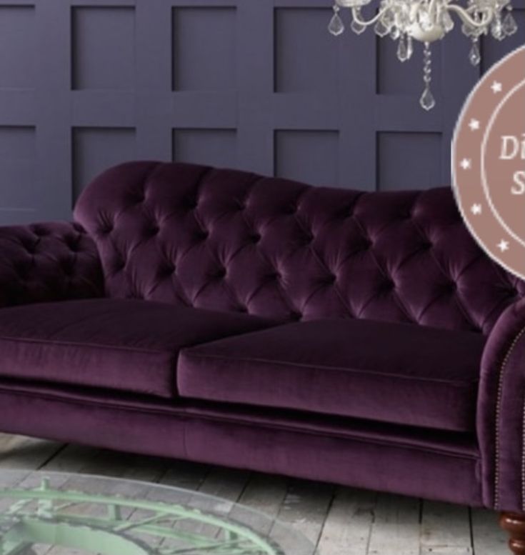 a purple couch sitting in front of a chandelier