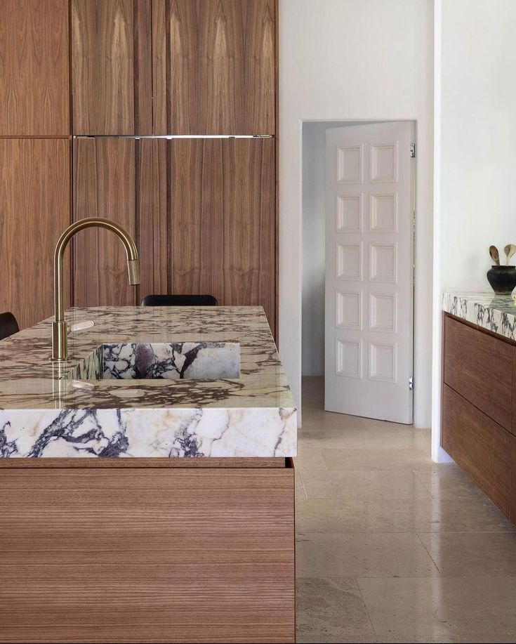 a kitchen with marble counter tops and wooden cabinets