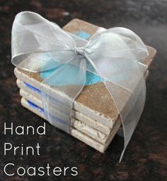 a stack of coasters with a bow tied around the top and text that reads hand print coasters