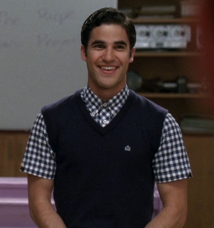 the young man is smiling while standing in front of a whiteboard