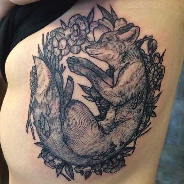 a woman's thigh with an image of a fox and flowers on the side