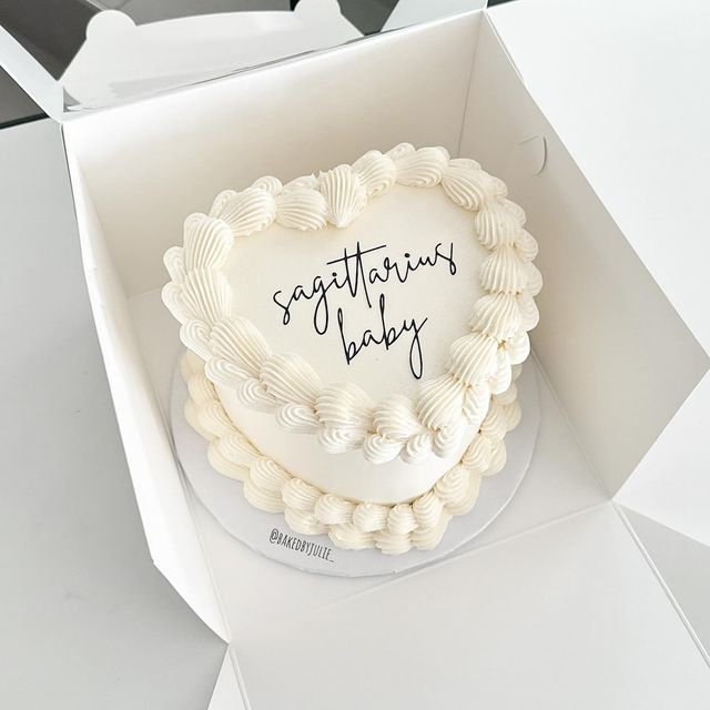 a heart shaped cake in a box with congratulations baby written on the top and bottom